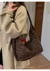 Detail of retro leopard print tote bag with brown leather strap and colorful pompom