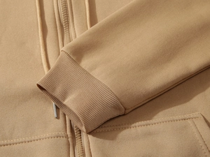 Detail of khaki zip-up hoodie featuring ribbed cuffs and high-quality metal zipper