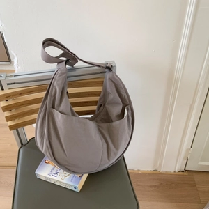 Detail of grey nylon crescent bag with large front pocket and adjustable wide strap