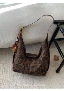 Detailed close-up of brown paisley hobo bag with colorful tassel and texture details