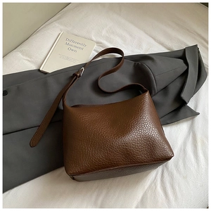 Detail shot of brown lychee grain leather tote bag with an adjustable shoulder strap