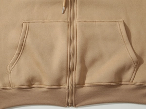 Close-up of khaki zip-up hoodie featuring kangaroo pockets and ribbed hem texture