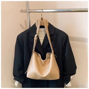 Close-up of beige lychee grain tote bag showing soft texture and adjustable strap