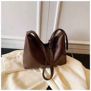 Detail of dark brown tote bag with premium lychee texture and adjustable shoulder strap