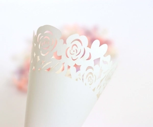 Detailed laser-cut hollow rose and heart patterns on premium white wedding confetti cones