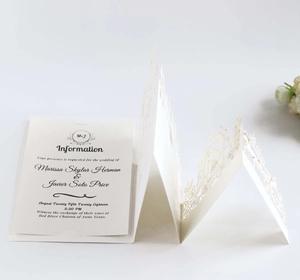 Elegant laser cut floral wedding invitation set with white outer shell and beige insert