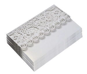 Detail of laser-cut lace floral patterns on cream pearl paper wedding invitations