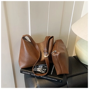 Detail of dark brown leather tote and matching pouch set with classic lychee grain texture