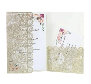 Detail of laser-cut gold glitter wedding invitation sleeve with floral inner card