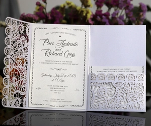 Detailed laser-cut lace floral pattern on blue wedding invitation with inner sample card