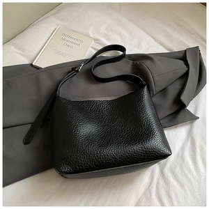 Close-up of black lychee texture PU leather underarm bag with silver buckle