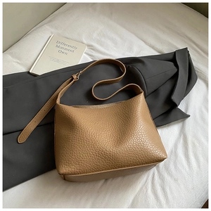 Detail of lychee pattern leather texture and adjustable metal buckle on hobo bag