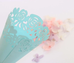 Close-up of laser-cut light blue pearl paper cone with delicate rose pattern for weddings