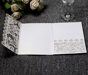 Detailed macro view of laser-cut white lace wedding invitation sleeve with elegant pattern