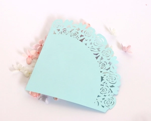 Detail of light blue laser-cut paper cone with delicate rose patterns for wedding petals