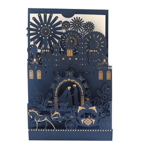 Detail of laser-cut navy wedding invitation featuring gold foil castle and couple silhouette