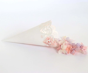 Close-up of laser-cut white heart confetti cones for wedding petals and dried flowers