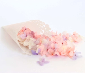 Close-up of preserved hydrangea petals in pastel colors with laser-cut lace paper cone