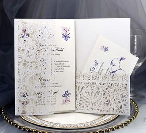 Laser cut white floral wedding invitation set with petal lace detail on a dinner plate