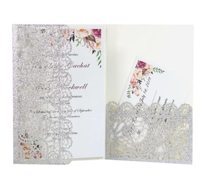 Detail of silver glitter laser-cut invitation sleeve with floral inner card and RSVP