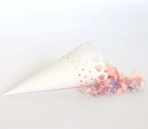 Close-up of white hollow heart lace paper cones filled with purple flower petals