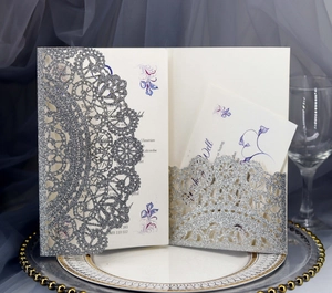 Macro view of laser-cut glitter silver wedding invitation with elegant floral insert