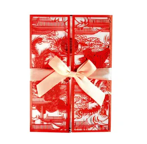 Detail of red laser-cut wedding card with phoenix pattern and champagne satin bow