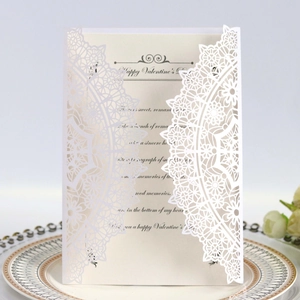 Detail showing the intricate laser-cut mandala patterns on a white pearlescent invitation