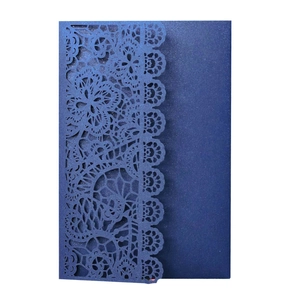 Macro detail of laser-cut navy blue lace invitation cover with elegant pearl paper texture