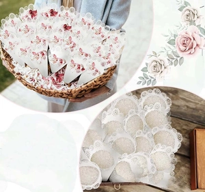 Close-up of laser-cut white paper cones with rose floral print for wedding confetti