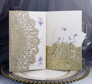 Detailed laser-cut wedding invitation set with glitter finish on elegant ceramic plate