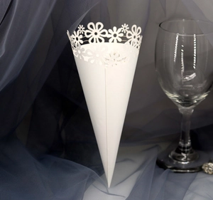 Close-up of laser-cut hollow lace patterns on a white paper wedding confetti cone