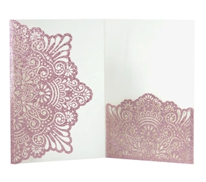Detail of pink glitter laser-cut wedding invitation with mandala floral design