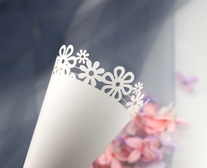 Detail of laser-cut flower pattern on white cone paper for wedding confetti