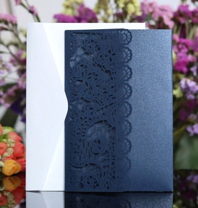 Detail showing the intricate laser-cut floral lace on navy blue pearl paper invitations