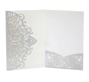 Macro detail of laser-cut floral lace invitation with shimmering silver glitter finish