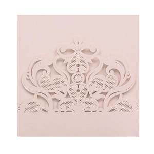 Detail of pink laser-cut wedding invitation featuring intricate floral lace patterns