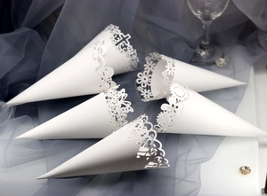 Macro view of white laser cut paper wedding cones with delicate lace and floral patterns