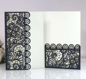 Detail of laser-cut wedding invitation featuring navy glitter paper and lace pattern