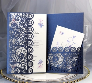 Detailed laser-cut navy blue lace invitation set with white insert and RSVP card on satin