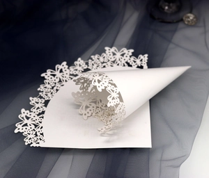 Dettaglio del cono per coriandoli da matrimonio con farfalla intagliata al laser in carta bianca