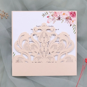 Macro detail of laser-cut lace wedding invitation with floral insert on mesh