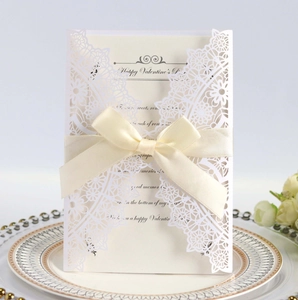 Laser cut white floral wedding invitation card with elegant cream ribbon and inner page