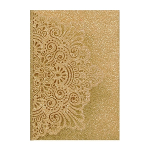Detail of elegant gold glitter wedding invitation with intricate lace mandala cutout