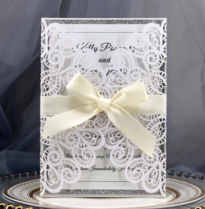Laser cut white wedding invitation with peacock lace, silver glitter base and silk bow