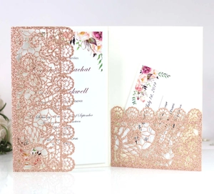 Detail of rose gold glitter wedding invitation with laser-cut lace and floral insert card