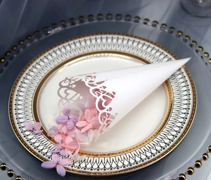 Detail of laser-cut white heart confetti cone on elegant vintage gold plate