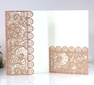 Detail of rose gold glitter laser-cut lace wedding invitation cover with floral pattern