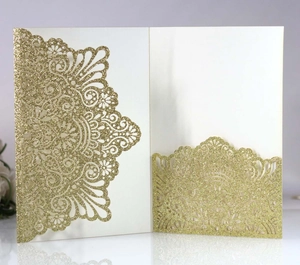 Detail of laser-cut gold glitter invitation card with intricate mandala floral patterns