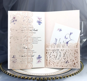 Detailed view of laser-cut wedding invitation card on a gold-rimmed decorative tray